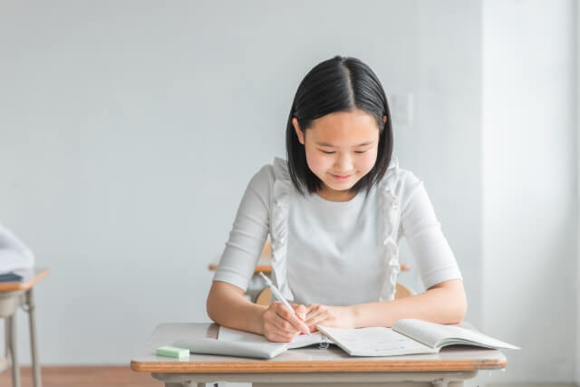 教室で勉強に集中する女子学生