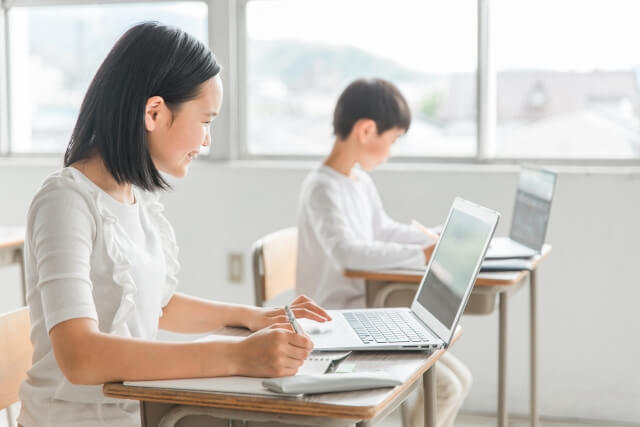 教室でノートパソコンを使う生徒たち